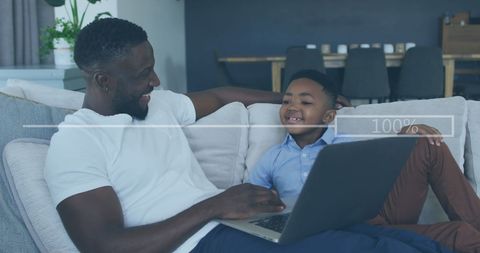 Father and Son Using Laptop with Digital Progress Bar Interface