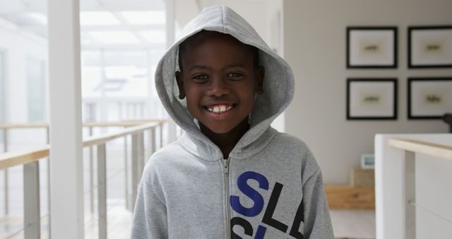 Portrait of happy african american boy wearing hoodie smiling at home. Lifestyle, childhood and domestic life, unaltered.