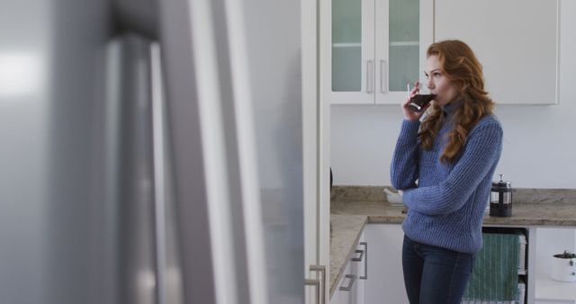 Woman Drinking Coffee in Modern Kitchen with Thoughtful Expression - Download Free Stock Images Pikwizard.com