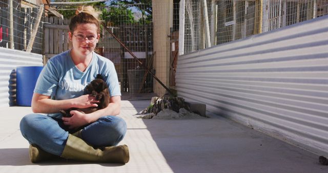 Young Woman Sitting Outdoors Holding Puppy in Bright Daylight - Download Free Stock Images Pikwizard.com