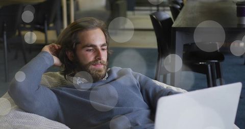 Man Relaxing with Laptop in Comfortable Office Lounge Setting