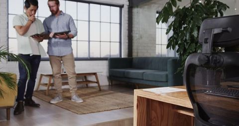 Business Professionals Collaborating on Tablet in Stylish Office