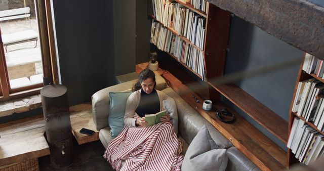 Woman Relaxing with Book on Cozy Couch in Modern Library - Download Free Stock Images Pikwizard.com