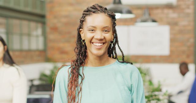 Confident Woman with Braided Hair Smiling in Office Environment - Download Free Stock Images Pikwizard.com