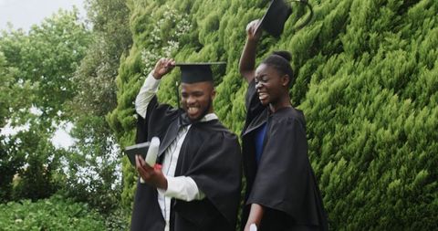 Graduation Celebration Outdoors with Diplomas and Smartphone