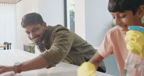 Father and Son Cleaning Dining Table Together Enthusiastically