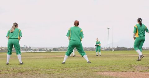Softball players united in ready position on field during game