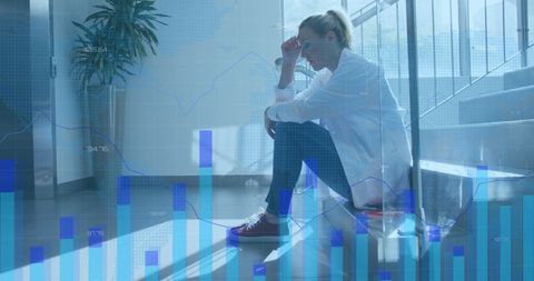 Healthcare worker sitting stressed against data backdrop