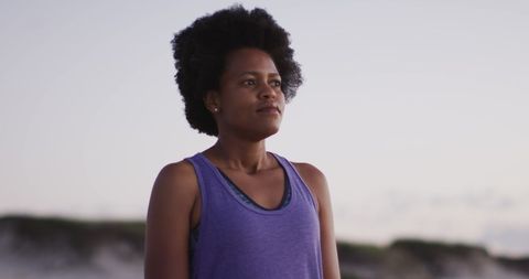 Confident African Woman in Sportswear on Beach at Sunrise