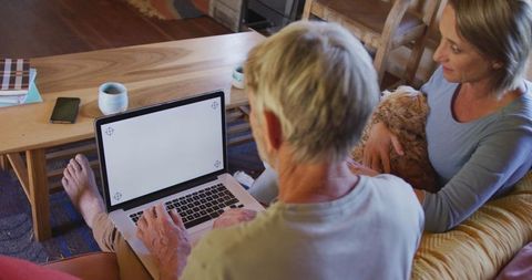 Senior Couple Relaxing with Dog and Laptop in Cozy Living Room