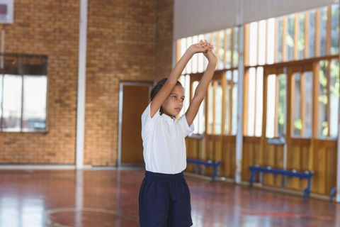 Young Student Stretching in School Gym for Fitness Training