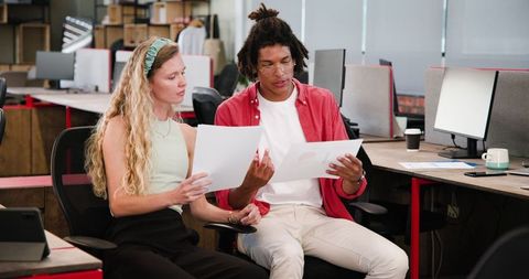 Young professionals discussing documents in modern office