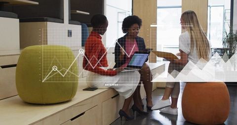 Diverse team collaborating on laptop and tablet in modern office lounge with data overlay