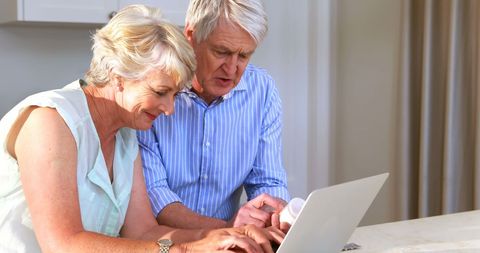 Senior Couple Using Laptop to Verify Medication Information