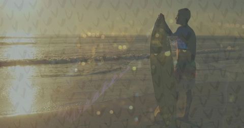 Surfer holding board on sunset beach with warm golden light, bokeh pattern overlay