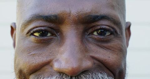 Smiling senior african american man showing wrinkles and gray beard closeup portrait