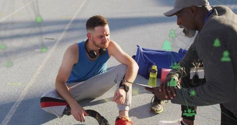Athlete and Coach Analyzing Performance with Digital Technology at Track