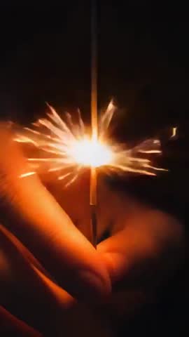 Hand Holding Sparkler While Lighter Igniting Core Sparks Radiating at Night