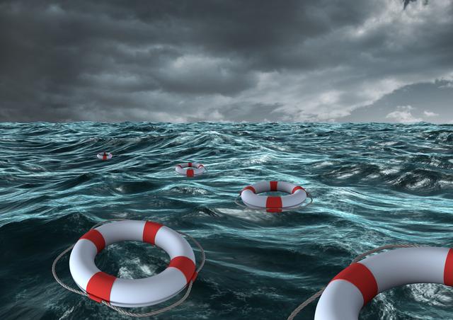 Lifebuoys float on turbulent ocean waves under dark stormy skies. Perfect for illustrating themes of maritime safety, survival, emergency preparedness, or along with articles about sea rescue operations. Suitable for websites, presentations, and educational materials focusing on water safety and emergency situations.