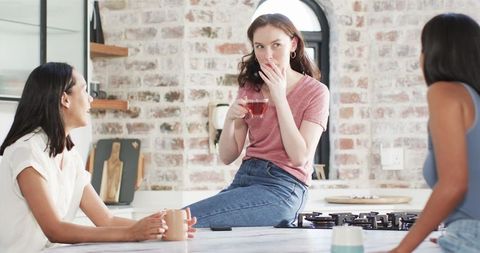 Friends Celebrating Engagement Over Tea in Cozy Kitchen