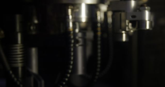 Close-up view of industrial machine parts, with a blurred focus creating a soft effect. Ideal for use in articles or presentations on manufacturing technology, industrial processes, and state-of-the-art engineering. Can also be used for marketing materials related to machinery and equipment manufacturing.