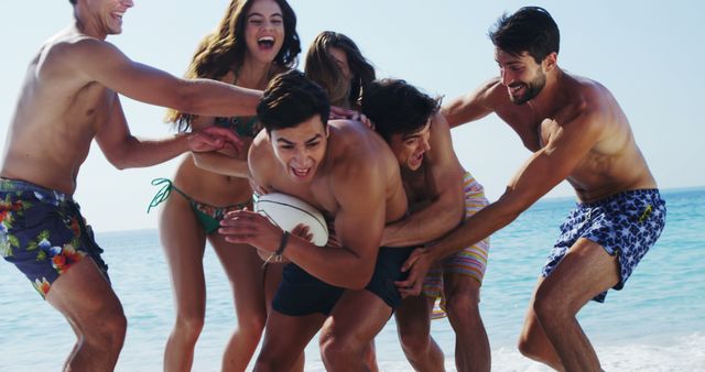 Group of young friends playing rugby on a sunny beach, enjoying their summer vacation. Perfect for usage in ads promoting summer activities, vacation packages, youth fitness programs, or beach sports events. Highlights themes of friendship, outdoor fun, and healthy living.