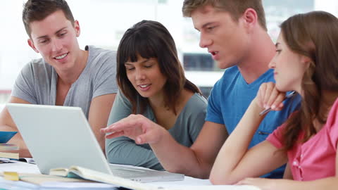 Diverse Group of Focused Students Collaborating on Laptop