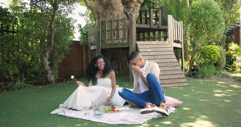 Diverse Couple Enjoying Picnic Outdoors Sharing Laughter