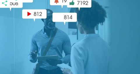 Colleagues discussing data with floating social media icons