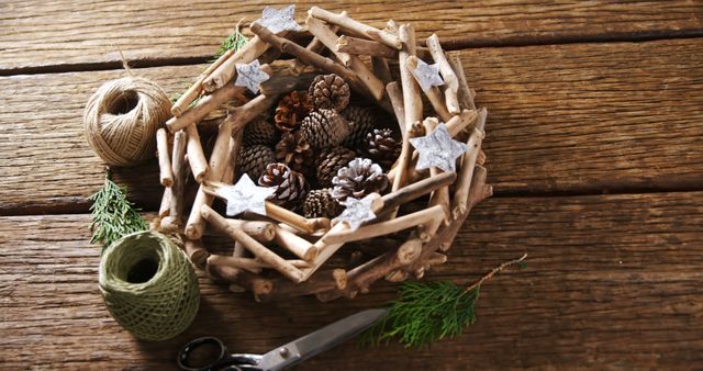 A rustic Christmas wreath made of twigs and pine cones lies on a wooden surface, with copy space - Download Free Stock Photos Pikwizard.com