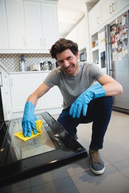 Man cleaning gas oven in kitchen at home
