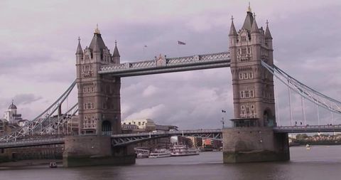 Tower Bridge spanning River Thames with twin towers and riverboats, London landmark