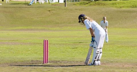 Female Cricketer Batting on Sunny Day with Pink Stumps