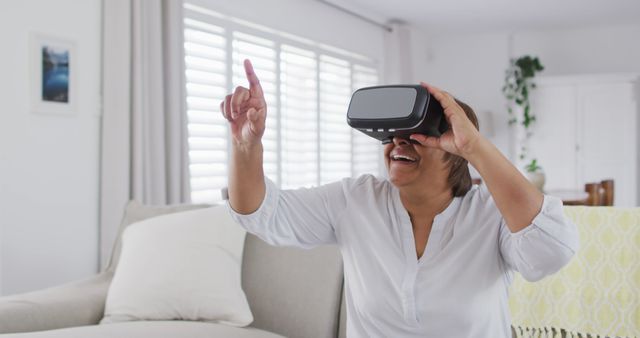 Senior woman exploring virtual reality in modern living room - Download Free Stock Images Pikwizard.com