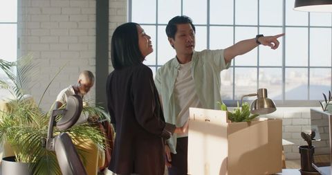 Colleagues discussing office setup in modern workspace