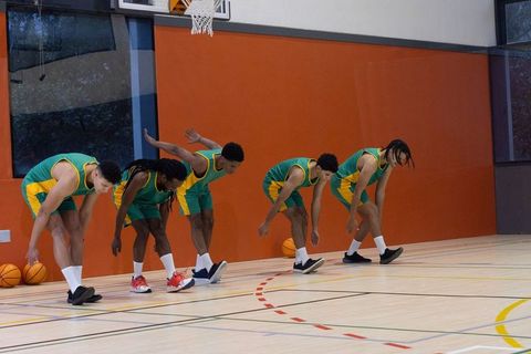 Diverse basketball team practicing dynamic moves indoors