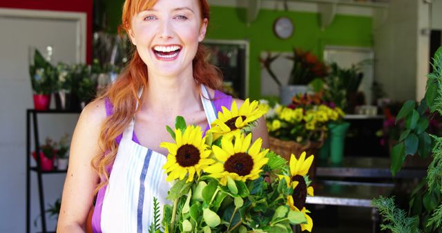 Young female florist smiling and holding a beautiful bouquet of sunflowers in a vibrant flower shop. Ideal for illustrating small businesses, florist profession, customer service excellence, and cheerful Springtime or Summer themes.