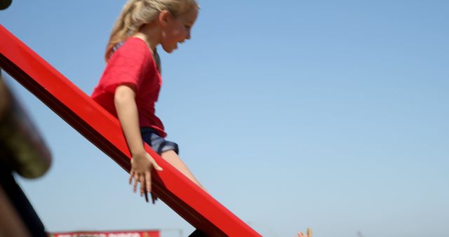 Joyful Child Sliding Down Playground Slide on Sunny Day - Download Free Stock Images Pikwizard.com