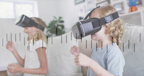 Kids playing with vr headsets on couch gesturing and interacting with virtual reality game