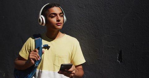 Young man outdoor listening to music on headphones
