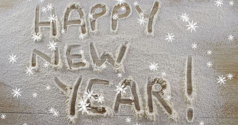 Happy New Year Message Written in Snow with Falling Snowflakes