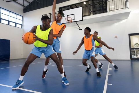Basketball Players in Action Pivoting on Indoor Court