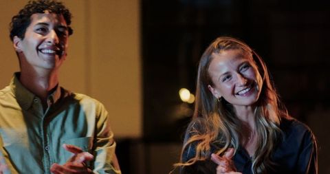 Diverse Colleagues Applauding in Office During Night Meeting