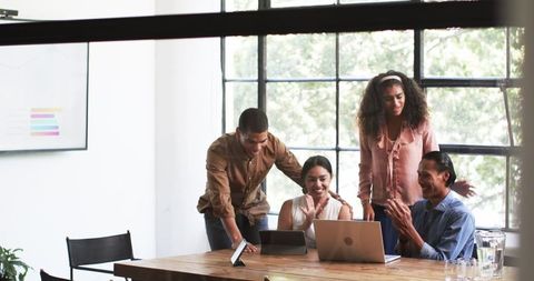Diverse Team Celebrating Achievement During Office Meeting