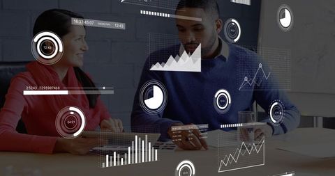 Colleagues Reviewing Digital Charts with Data Overlays in Modern Office