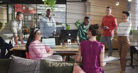 Leader presenting to diverse team in modern open-plan office during collaborative meeting
