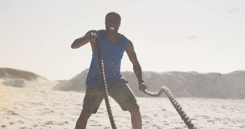 Athletic Man Performing Battle Rope Exercise on Beach