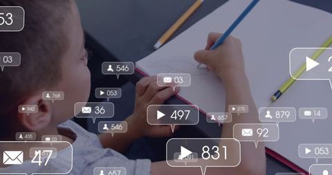 Schoolboy drawing while floating social media notifications overlaying sketchbook and desk