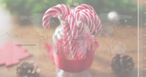Candy cane jar with red ribbon and dotted world map overlay holiday still life