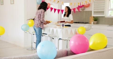 Women Preparing Birthday Festivities with Colorful Decorations